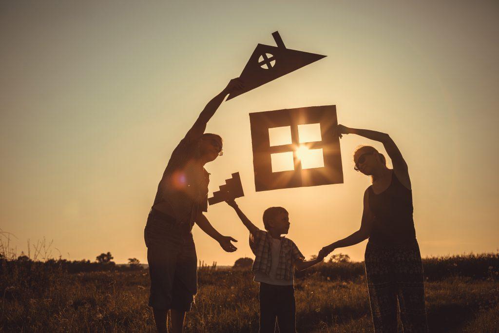 Famille qui tient des éléments de la maison pour la construire